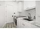 Laundry room features a stainless steel sink, ample counter space and white cabinets at 307 Palmetto Ln, Largo, FL 33770
