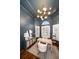 Sophisticated home office with blue walls, shuttered windows, and a stylish desk at 307 Palmetto Ln, Largo, FL 33770