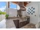 Outdoor kitchen boasts stainless steel grill, granite countertops, and decorative backsplash at 307 Palmetto Ln, Largo, FL 33770