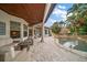 Inviting patio features outdoor seating, a pool with a tiki hut, and lush tropical landscaping at 307 Palmetto Ln, Largo, FL 33770