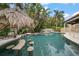 Tropical pool area featuring a tiki hut and bar stools within the refreshing pool at 307 Palmetto Ln, Largo, FL 33770