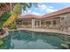 A backyard pool is surrounded by a fence, a patio, and the back of the home with a red tile roof at 307 Palmetto Ln, Largo, FL 33770