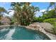 Beautiful pool featuring lush tropical landscaping, a small waterfall, and a charming tiki hut at 307 Palmetto Ln, Largo, FL 33770