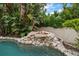 The pool features a small rock waterfall with lush vegetation and a decorative clay pot at 307 Palmetto Ln, Largo, FL 33770