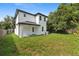 View of the home's backyard and the exterior elevation featuring black trim at 3105 E Osborne Ave, Tampa, FL 33610