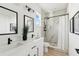 Modern bathroom featuring double sinks, black hardware, and a walk-in shower with marble tile at 3105 E Osborne Ave, Tampa, FL 33610