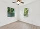 Well-lit bedroom featuring two windows, light colored walls, and wood-look flooring at 3105 E Osborne Ave, Tampa, FL 33610