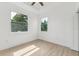 Bright, empty bedroom with hardwood floors, two large windows, and plenty of natural light at 3105 E Osborne Ave, Tampa, FL 33610