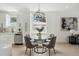 Dining table with gray chairs adjacent to a modern kitchen with white cabinets and stainless steel appliances at 3105 E Osborne Ave, Tampa, FL 33610