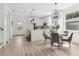 Sunlit dining area with a glass table, modern chairs, stylish light fixture, and open concept to the kitchen at 3105 E Osborne Ave, Tampa, FL 33610