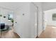 Bright hallway with light hardwood floors and white walls, leading to a bedroom and another room at 3105 E Osborne Ave, Tampa, FL 33610