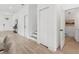 Hallway with light wood flooring, closet, and door to bathroom at 3105 E Osborne Ave, Tampa, FL 33610