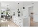 White kitchen with quartz island, stainless steel appliances, and a dining area at 3105 E Osborne Ave, Tampa, FL 33610