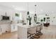 Bright modern kitchen featuring an island with white quartz countertops, pendant lights, and stainless steel appliances at 3105 E Osborne Ave, Tampa, FL 33610