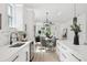 Open concept kitchen with white cabinetry, stainless steel appliances, light wood flooring, and dining area at 3105 E Osborne Ave, Tampa, FL 33610