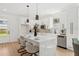 Well-lit kitchen with an island, white cabinetry, stainless steel appliances, and light wood flooring at 3105 E Osborne Ave, Tampa, FL 33610