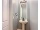 Powder room with pedestal sink, framed mirror, and sconce lighting at 3111 W De Leon St # 2, Tampa, FL 33609