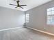 Bedroom with neutral walls and carpet, two bright windows, and a ceiling fan at 3111 W De Leon St # 2, Tampa, FL 33609