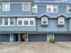 Charming townhome featuring a blue exterior, gray garage doors and beautiful brick driveway at 3111 W De Leon St # 2, Tampa, FL 33609