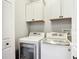 Laundry room features white cabinets and modern washer and dryer units at 3111 W De Leon St # 2, Tampa, FL 33609