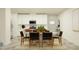 Inviting dining area featuring a stylish table with black weave chairs and a view of the modern, white kitchen at 32066 Griffin Sands Ln, San Antonio, FL 33576