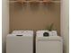 Functional laundry room featuring a side-by-side washer and dryer with overhead shelving for storage at 32066 Griffin Sands Ln, San Antonio, FL 33576