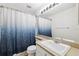 Cozy bathroom with large mirror, and a shower featuring a blue shower curtain at 3209 Meta Ct, Largo, FL 33771