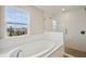 Modern bathroom featuring a soaking tub with a view and a glass-enclosed shower with pebble floor at 3483 Yellow Leaf Cir, Spring Hill, FL 34609