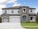 Elegant two-story home featuring a stone facade, a two-car garage, and a well-manicured lawn at 3483 Yellow Leaf Cir, Spring Hill, FL 34609