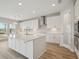 Bright kitchen with an island, white cabinets, quartz countertops, and modern stainless-steel appliances at 3483 Yellow Leaf Cir, Spring Hill, FL 34609
