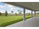 Covered patio overlooking a large grassy lawn and palm trees at 3483 Yellow Leaf Cir, Spring Hill, FL 34609