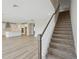 Carpeted staircase with wooden handrail adjacent to the modern, open kitchen at 3483 Yellow Leaf Cir, Spring Hill, FL 34609