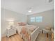 Cozy bedroom with wood-look floors, bright natural light, a ceiling fan, and a comfortable chair at 3504 Wedge Way, New Port Richey, FL 34655