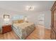 Bright bedroom featuring a floral comforter, hardwood floors, an ensuite bathroom, and a spacious wardrobe at 3504 Wedge Way, New Port Richey, FL 34655