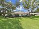 Charming home featuring a cozy lanai, well-manicured lawn, and mature trees for shade at 3504 Wedge Way, New Port Richey, FL 34655
