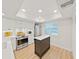 Bright kitchen features white cabinetry, stainless steel appliances, and an island, offering a modern and functional space at 3504 Wedge Way, New Port Richey, FL 34655