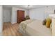 Serene main bedroom featuring light wood floors, a large armoire, and a comfortable bed with decorative pillows at 3504 Wedge Way, New Port Richey, FL 34655