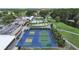 Aerial perspective of tennis and pickleball courts, near the clubhouse and golf course; golf carts parked nearby at 3504 Wedge Way, New Port Richey, FL 34655