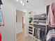Well-lit walk-in closet with custom shelving and hanging space, adjoining the main bedroom at 3504 Wedge Way, New Port Richey, FL 34655