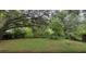 View of backyard featuring a grassy area and mature trees offering shade at 3513 Danny Bryan Blvd, Tampa, FL 33619