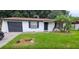 Well-kept single-story home with a dark garage door and lush lawn, featuring a small garden bed at 3513 Danny Bryan Blvd, Tampa, FL 33619