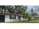Charming single story home features a bright red front door and a neatly maintained lawn at 3513 Danny Bryan Blvd, Tampa, FL 33619