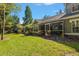 Exterior view of the screened-in lanai and landscaped backyard at 3521 Kings Rd # 105, Palm Harbor, FL 34685