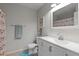 Charming bathroom featuring bright white vanity, decorative shower curtain, and a cozy atmosphere at 3521 Kings Rd # 105, Palm Harbor, FL 34685