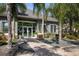 Exterior of building featuring well-manicured plants and trees with a stone-paver walkway leading to the entrance at 3521 Kings Rd # 105, Palm Harbor, FL 34685