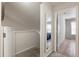 Upstairs hallway with view of carpeted landing and doorway leading to light filled bedroom at 3521 Kings Rd # 105, Palm Harbor, FL 34685