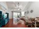Bright living room boasts wood floors, vaulted ceilings, and sliding glass door to lanai at 3521 Kings Rd # 105, Palm Harbor, FL 34685