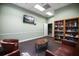 Inviting sitting room with two leather chairs, a bookshelf, table, and television at 3521 Kings Rd # 105, Palm Harbor, FL 34685