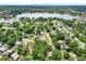 A panoramic aerial view showcasing a neighborhood with mature trees and a large lake in the background at 3615 Greatwood Ct, Land O Lakes, FL 34639