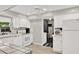Clean and bright kitchen featuring white cabinetry, tile countertops, and modern appliances at 3615 Greatwood Ct, Land O Lakes, FL 34639